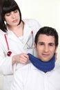 Female doctor putting neck brace to a patient