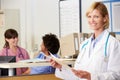 Female Doctor Reading Patient Notes At Nurses Station Royalty Free Stock Photo