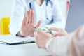 Female doctor refusing bribes or kickbacks, currencies dollar. Patient giving money for medical services. Concept of Royalty Free Stock Photo