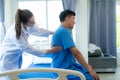 Female doctor's hand doing physiotherapy stretching the shoulder of a male patient. Royalty Free Stock Photo