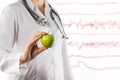 Female doctor's hand holding green apple. Close up shot on blurred medical background. Concept of Healthcare And Medicine. Copy sp Royalty Free Stock Photo