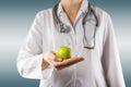 Female doctor's hand holding green apple. Close up Royalty Free Stock Photo