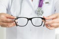 Female doctor's hands holding black glasses Royalty Free Stock Photo