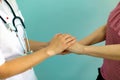 Female doctor`s hands holding patient`s hand for encouragement and empathy. Partnership, trust and medical ethics concept. Royalty Free Stock Photo