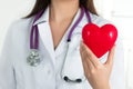 Female doctor's hands holding red heart