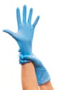 Female doctor's hands putting on blue sterilized surgical gloves