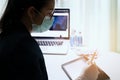 Female Doctor`s working on laptop computer, writing prescription notepad with record information on desk in hospital or clinic, Royalty Free Stock Photo