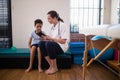 Female doctor showing digital tablet to boy against wall Royalty Free Stock Photo