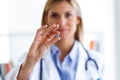 Female doctor showing pill to camera in the consultation. Royalty Free Stock Photo