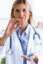 Female doctor showing pill to camera in the consultation. Royalty Free Stock Photo