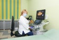 A female doctor sits in the office near the ultrasound machine Royalty Free Stock Photo