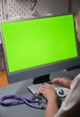 a female doctor sits in a white coat in front of a monitor with a green screen