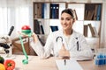 Female doctor sitting at desk in office with microscope and stethoscope. Woman is holding red apple with measuring tape. Royalty Free Stock Photo