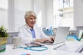 Female Doctor Sitting At Desk Working At Laptop In Office Royalty Free Stock Photo