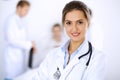 Female doctor smiling on the background with patient in the bed and two doctors Royalty Free Stock Photo