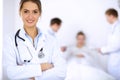 Female doctor smiling on the background with patient in the bed and two doctors Royalty Free Stock Photo
