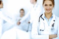 Female doctor smiling on the background with patient in the bed and two doctors Royalty Free Stock Photo