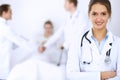 Female doctor smiling on the background with patient in the bed and two doctors Royalty Free Stock Photo