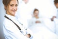 Female doctor smiling on the background with patient in the bed and two doctors Royalty Free Stock Photo