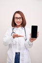 Female doctor smiling and showing a blank smart phone screen isolated on a white background Royalty Free Stock Photo