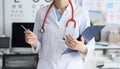 Female doctor is standing office holding folder