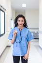 Female doctor stands at hospital. Healthcare worker. woman pharmacist with and stethoscope smiling satisfied with her job in hospi Royalty Free Stock Photo