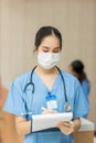 Female doctor stands at hospital. Healthcare worker. woman pharmacist with and stethoscope smiling satisfied with her job in hospi Royalty Free Stock Photo