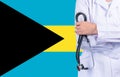 Female doctor with stethoscope in hand on the background of the Bahamas flag. Concept medicine, pandemic in the country Royalty Free Stock Photo