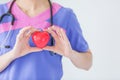 Female doctor with stethoscope holding red heart, isolated on white background, heart healthy care concept with copy space. Royalty Free Stock Photo