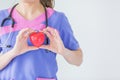 Female doctor with stethoscope holding red heart, isolated on white background, heart healthy care concept with copy space. Royalty Free Stock Photo