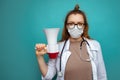 Female doctor with stethoscope and mask holds megaphone