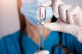 Female doctor with a stethoscope on shoulder holding syringe and Coronavirus vaccine. Healthcare And Medical concept