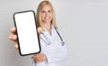 Female Doctor With Stethoscope Showing Big Blank Smartphone At Camera Royalty Free Stock Photo
