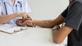 Female doctor wearing stethoscope and patient checking pulse, medical concept