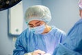 Female Doctor in Surgery Operating Hospital Room. Surgeon medic in protective work wear gloves, mask and cap