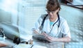 Female doctor taking notes on clipboard; light effect Royalty Free Stock Photo