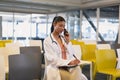 Female doctor talking on mobile phone while writing on a clipboard Royalty Free Stock Photo
