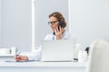 female doctor talking by phone and writing in clipboard Royalty Free Stock Photo