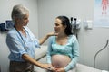 Female doctor talking with pregnant woman in examination room Royalty Free Stock Photo