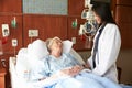 Female Doctor Talks To Senior Female Patient In Hospital Bed Royalty Free Stock Photo