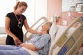 Female Doctor Talks To Senior Female Patient In Hospital Bed Royalty Free Stock Photo