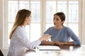 Female doctor therapist consulting young woman at medical appointment