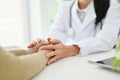 Female doctor touching her patient hands to make her patient feel relaxed and reassured. close-up