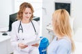 Female doctor transmits to young pregnant woman with blonde hair the results and reports Royalty Free Stock Photo