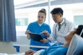 A female doctor and two male doctors treat a young male patient in bed and are talking Royalty Free Stock Photo