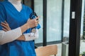 Female doctor in uniform holding a stethoscope waiting to examine a patient. A female doctor holds a stethoscope to prepare for