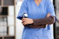 Female doctor in uniform holding a stethoscope waiting to examine a patient. A female doctor holds a stethoscope to prepare for