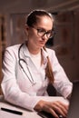Female doctor using laptop working on night shift in clinic Royalty Free Stock Photo