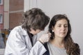 Female doctor using otoscope with a girl patient.