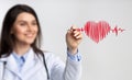 Female Doctor Using Stylus Drawing Heart Rate On Invisible Screen